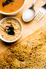 Onion rava masala dosa is a South Indian instant breakfast served with chutney and sambar over moody background. selective focus