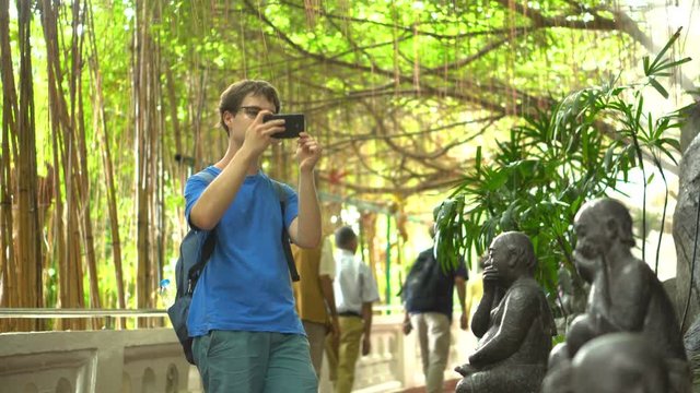 Caucasian Tourist Taking Photo With Smartphone in Asian Temple