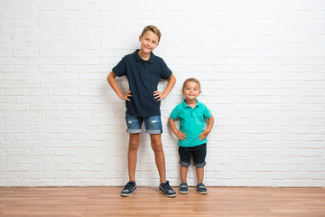 Two little brothers posing with arms at hip and smiling