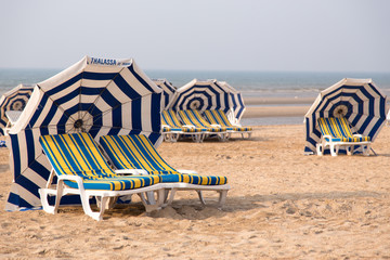 Pairs of longchairs with umbrella on the beach.