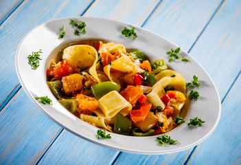 Pasta with vegetables on wooden background