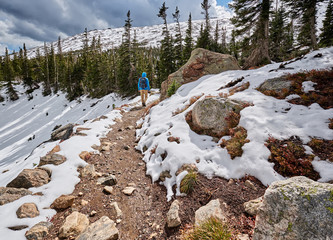 Tourist with backpack hiking on snowy trail