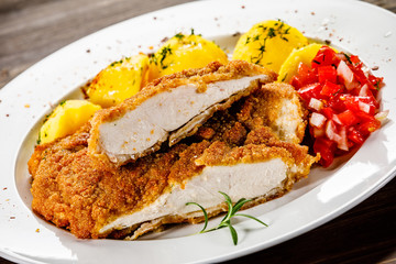 Fried pork chop, boiled potatoes and vegetable salad