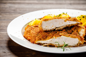 Fried pork chop, boiled potatoes and vegetable salad