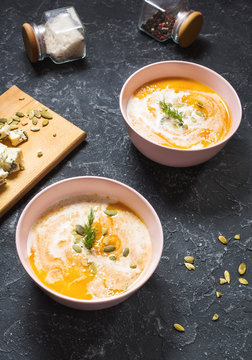 Thick pumpkin soup with feta cheese on stone background.