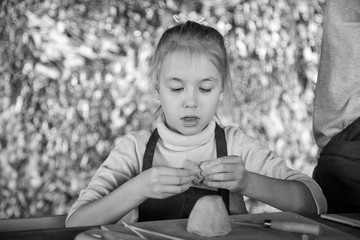 Blonde girl sculpts from clay in studio. Artclass