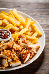 Kebab - grilled meat with french fries and vegetables on wooden background