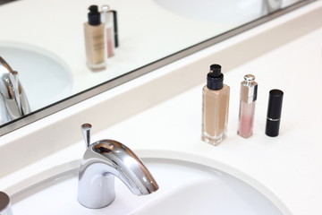 洗面台に置かれたファンデーションとリップスティック	