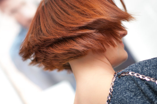 Accurate geometric shape short haircut on a woman with red hair in detail