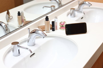 洗面でメイクをする　リキッドファンデーション、リップスティック、スマートフォン	