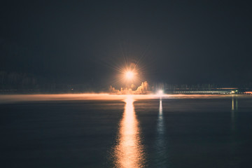 Powerfull lantern illuminating the river in the fog at night