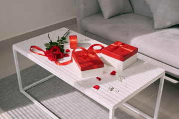 Valentine Day gifts and red rose on table.