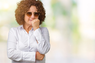 Beautiful middle ager senior business woman wearing sunglasses over isolated background looking stressed and nervous with hands on mouth biting nails. Anxiety problem.