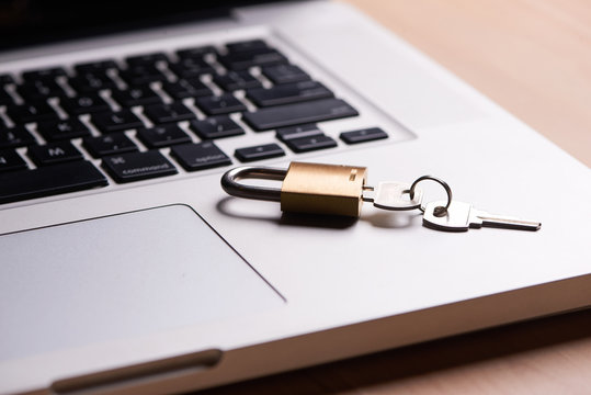 Computer security and data protection concept. Laptop with an locked lock and key on it.