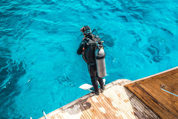 scuba diver sit on the yacht and ready to dive.