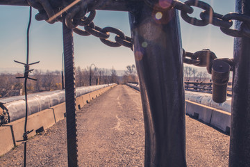 Lonely man behind barbed wire on the bridge