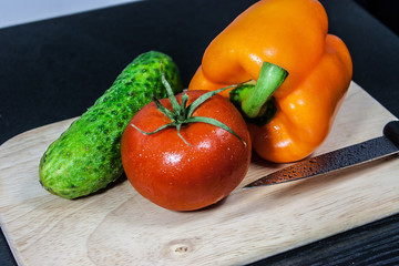 Vegetables for salad with knife on a cutting board