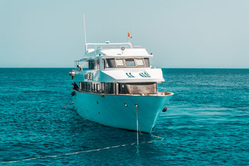 A large private motor yacht under way sailing out on tropical sea. Luxury yacht.