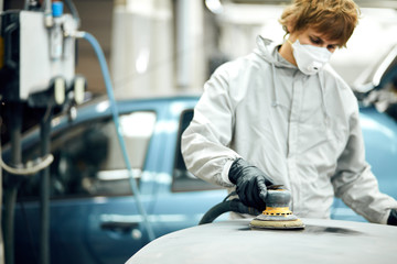 mechanic worker repairman sanding polishing car and preparing automobile for painting
