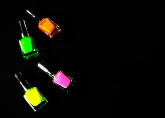 Neon nail polishes on a black background