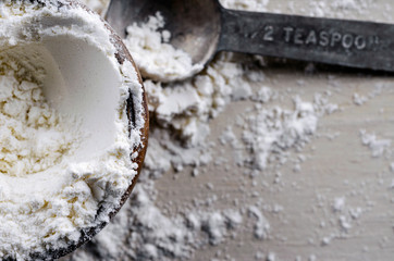 Close Up of a Wooden Bowl of Flour with a Metal Teaspoon