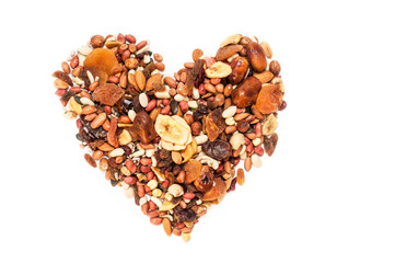 Delicious, useful dried fruits, nuts, bananas, dates are shaped in the shape of a heart on a white background