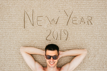 Happy excited smiling funny man lying topless on beach sand in sunglasses. Meeting and celebrating...