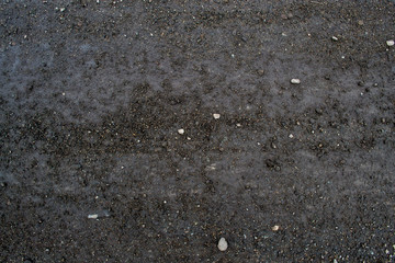 Texture of asphalt road with sand and stones and pits