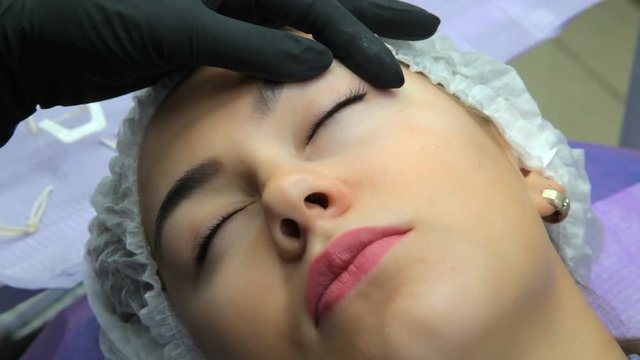  Permanent makeup. Permanent tattooing of eyebrows. Cosmetologist applying permanent make up on eyebrows- eyebrow tattoo.