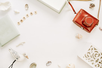 Frame border of travel styled composition with photo album, retro camera, bird sculpture on white background. Flat lay, top view traveler blog mock up.