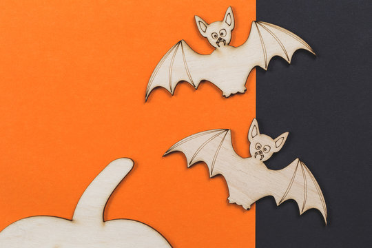Do it yourself Halloween pumpkin and vampire bats wooden cut outs on orange and black, flat lay