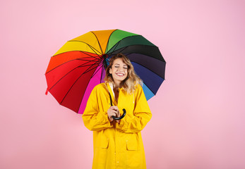 Woman with rainbow umbrella on color background © New Africa