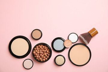 Flat lay composition with various makeup face powders on color background. Space for text