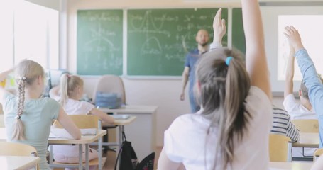 Teacher Writing Math Formula on Board During Lesson. The Teacher Asks the Question to the Class, the Pupil Rises Hands. Schoolgirl Answers the Question of the Teacher - Powered by Adobe