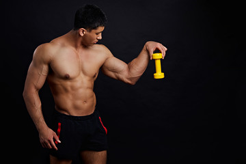 well-built man is going to throw a dumbbell. wrong tool. sportsman with light dumbbell. copy space