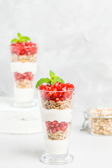 Pomegranate parfait - sweet organic layered dessert with granola flakes, yogurt and ripe fruit seeds.