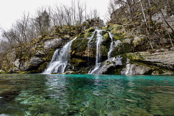 The Virje Waterfall is a multi-stranded waterfall 12 m in height and 20 m in width close to Bovec, Soča Valley, Slovenia Below, there is a beautiful pool in shades of green.