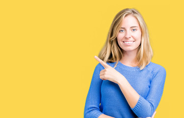 Beautiful young woman wearing blue sweater over isolated background Pointing with hand finger to the side showing advertisement, serious and calm face