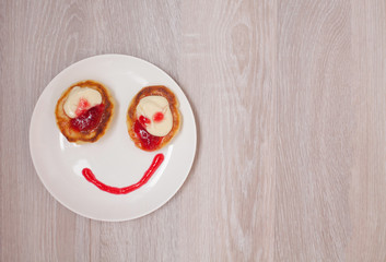 Summer cottage cheese pancakes on white plates on a table with jam, closeup, Smiling. Smile for sweet breakfast with love