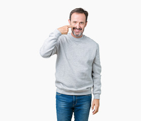 Handsome middle age senior man wearing a sweatshirt over isolated background Pointing with hand finger to face and nose, smiling cheerful