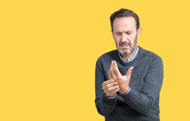 Handsome middle age senior man wearing a sweater over isolated background Suffering pain on hands...