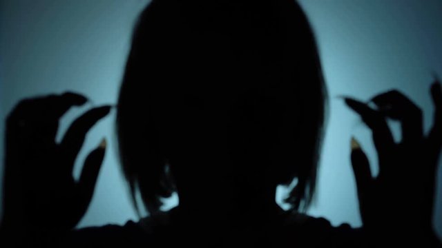 Demonic woman with sharp nails attacking camera, silent horrific scene, witch. Blood-chilling horror thriller shot