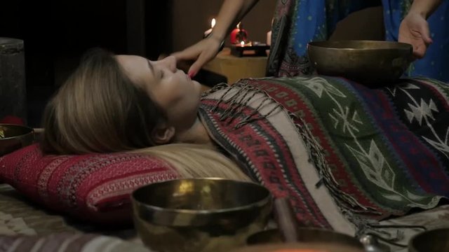 Woman operating with Tibetan singing bowls. yoga instructor conducts meditation. slow motion