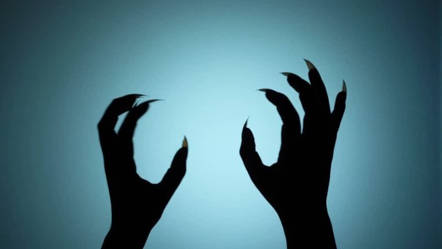 Shaky hands of a beast, monster hiding behind the wall, creepy horror silhouette. Blood-chilling horror thriller shot