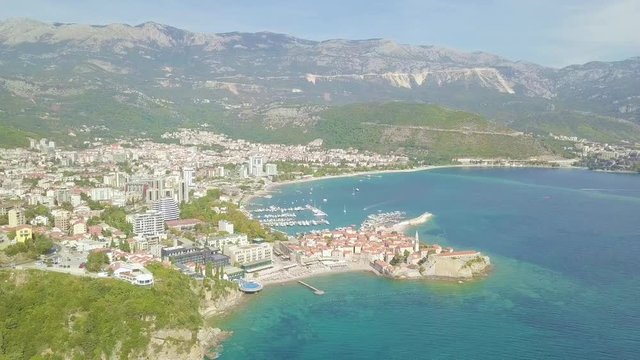 Flying above old town of Budva Montenegro towards city beach, Budva Marina and Adriatic sea with Dukley Zavala on background. Aerial footage.