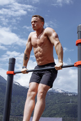 Powerful caucasian bodybuilder with perfect naked upper body with six-pack enjoying adorable...