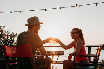 Couple enjoying sunset in a beach bar drinking beer