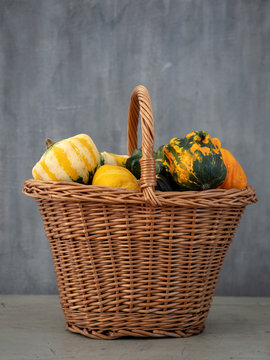 Pumpkins In Basket On Grey Background