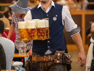 Oktoberfest, Munich, Germany. Waiter serving beers, closeup view