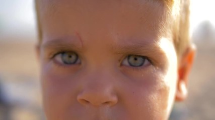4K Slow motion - Caucasian Child with blue eyes looking at the camera in a sunny day
